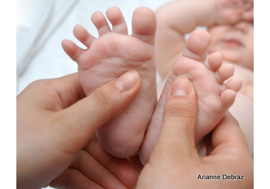 Mother massaging foots of her baby